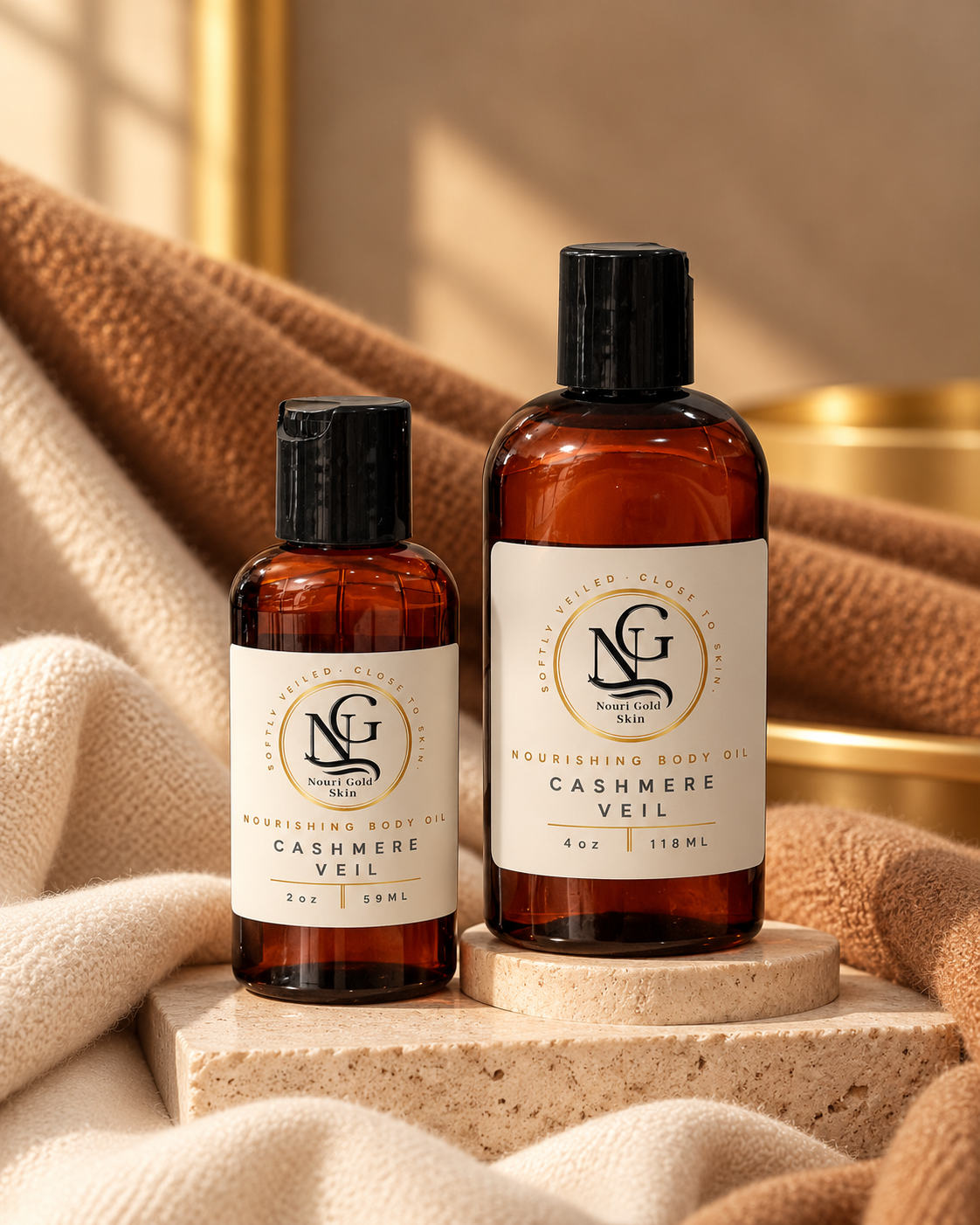 Two amber plastic bottles of nourishing body oil and cashmere veil by Silver Gold Salon, styled on a stone pedestal with soft beige towels in a warm, sunlit setting.