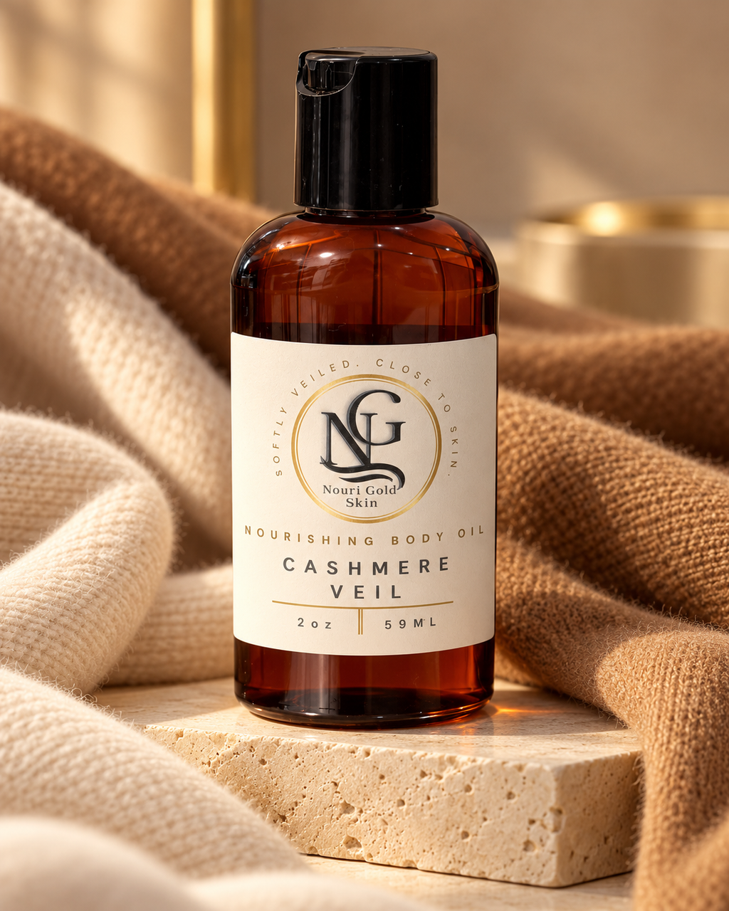 An amber plastic bottle of Nightlight Skincare Cashmere Veil nourishing body oil with a black cap and cream label, styled on a stone block with beige knit fabric.